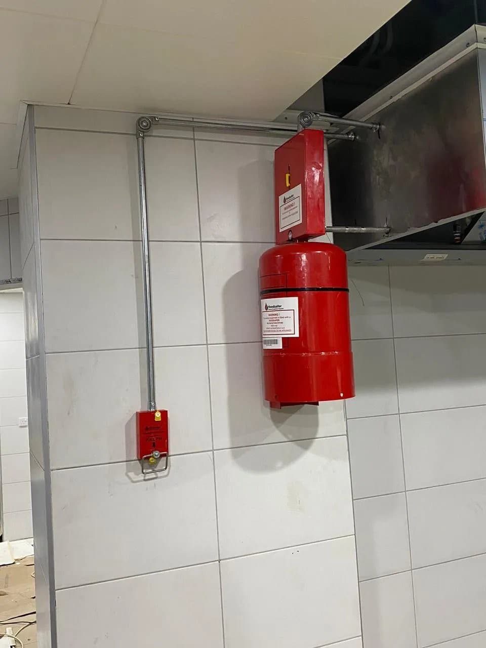HoodSafer-cylinder monterad på vägg i ett storkök