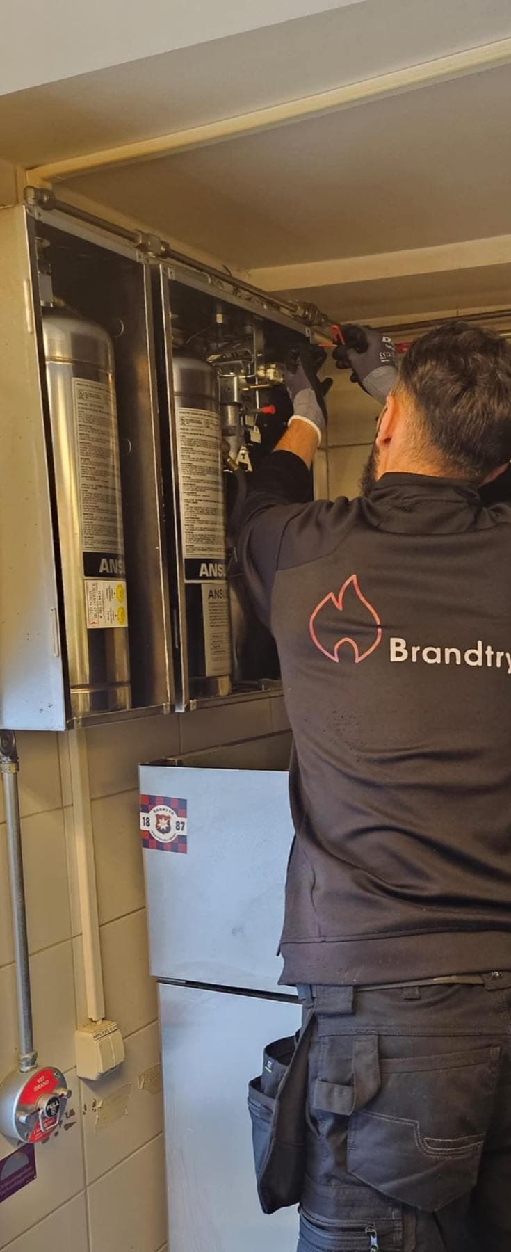 Tekniker utför service på ett kökssläcksystem